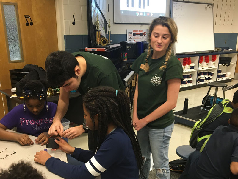 2 Tulane students helping elementary students