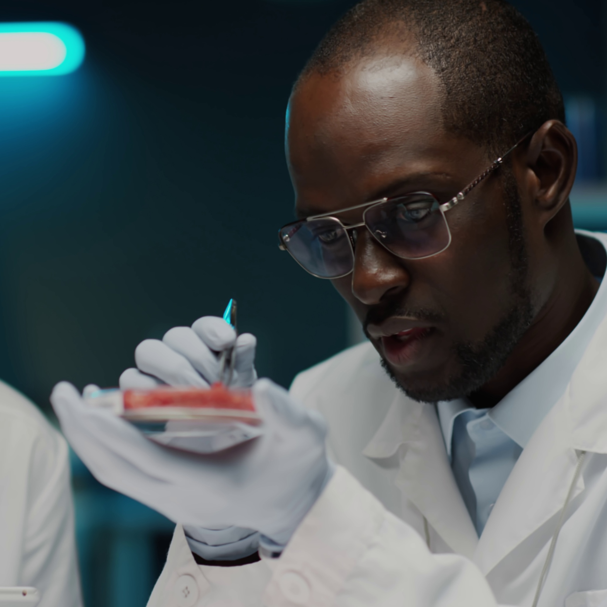 biotechnologist-using-tweezers-to-examine-cultured-meat-in-petri-dish