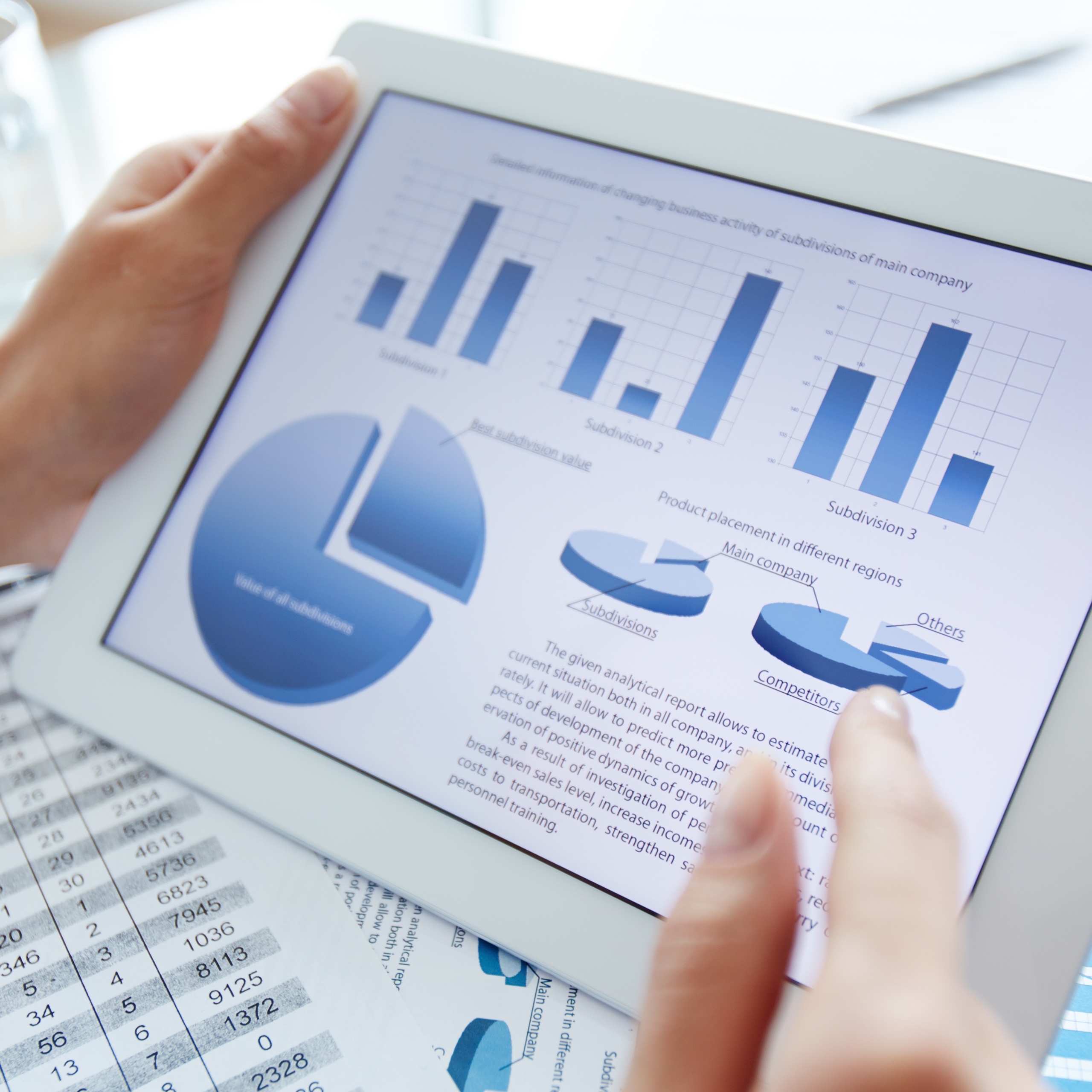 Person's hand pointing to a pie chart on a tablet screen.