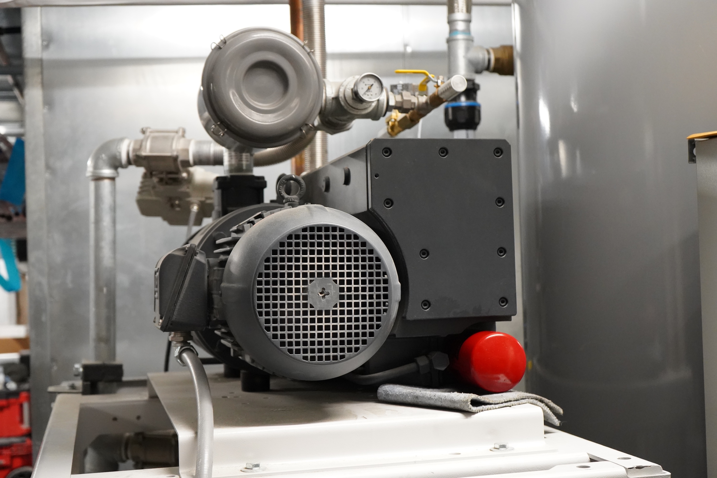 Industrial vacuum pump with motor and pipes.