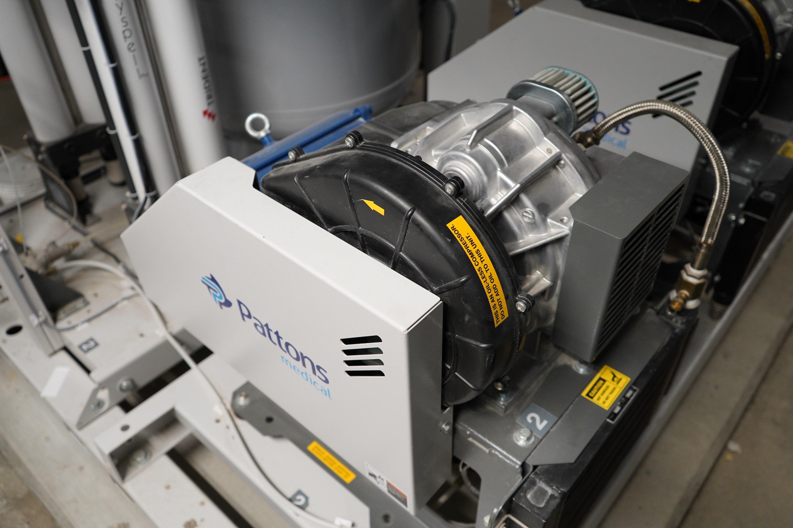 Industrial compressor unit with a white panel featuring a blue logo.