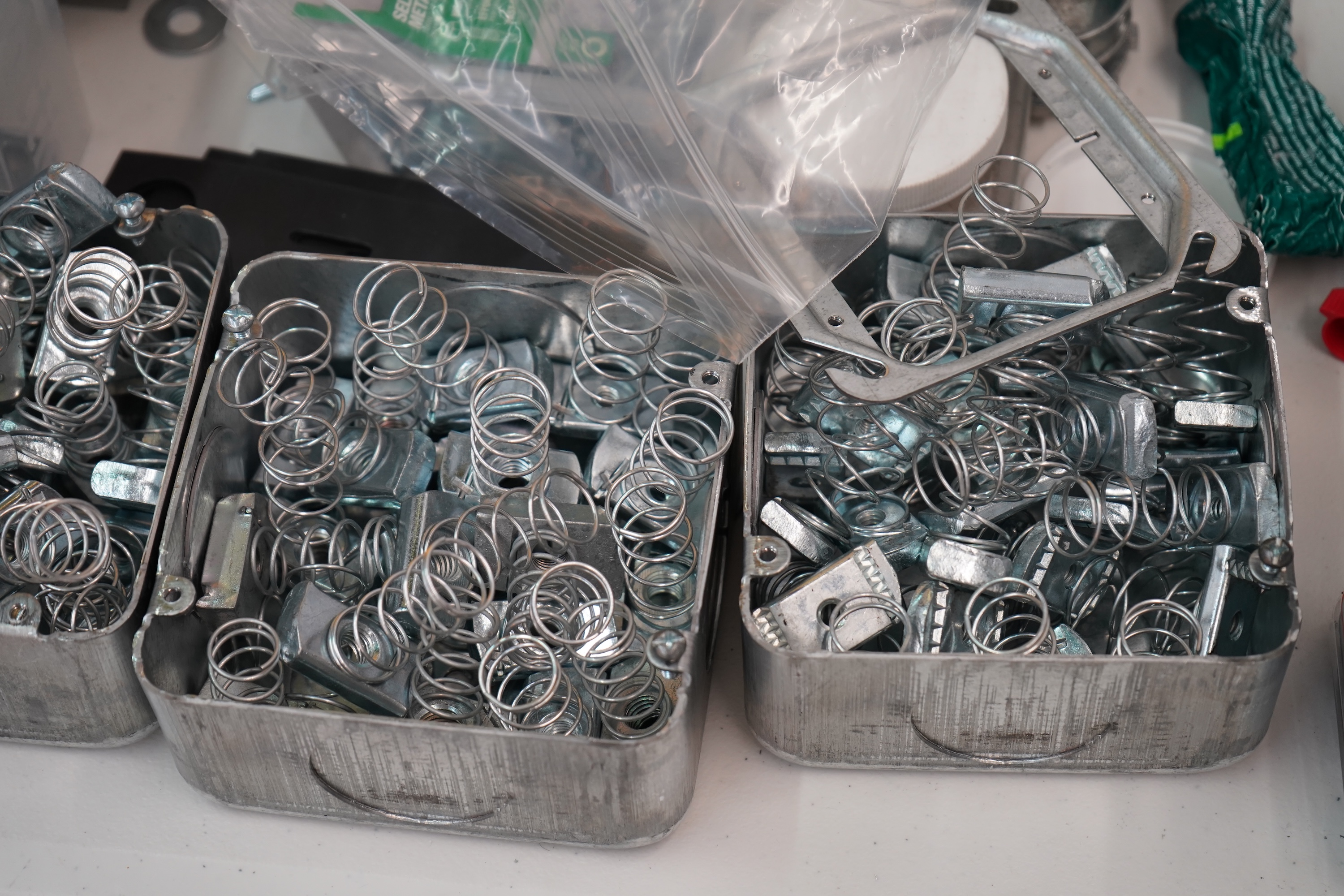 Two metal containers overflowing with shiny, coiled springs and hardware.