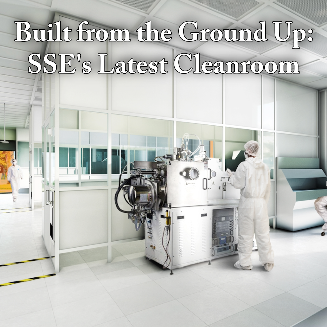 Cleanroom with scientists in white suits working on equipment.