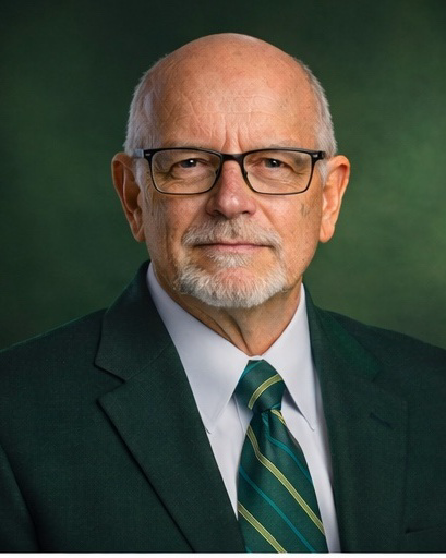 Portrait of an older man with glasses, wearing a suit and tie.