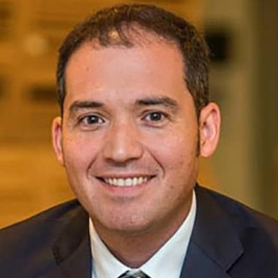 Headshot of a man smiling and wearing a suit.