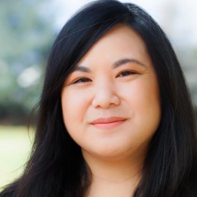 Headshot of woman with black hair smiling at camera