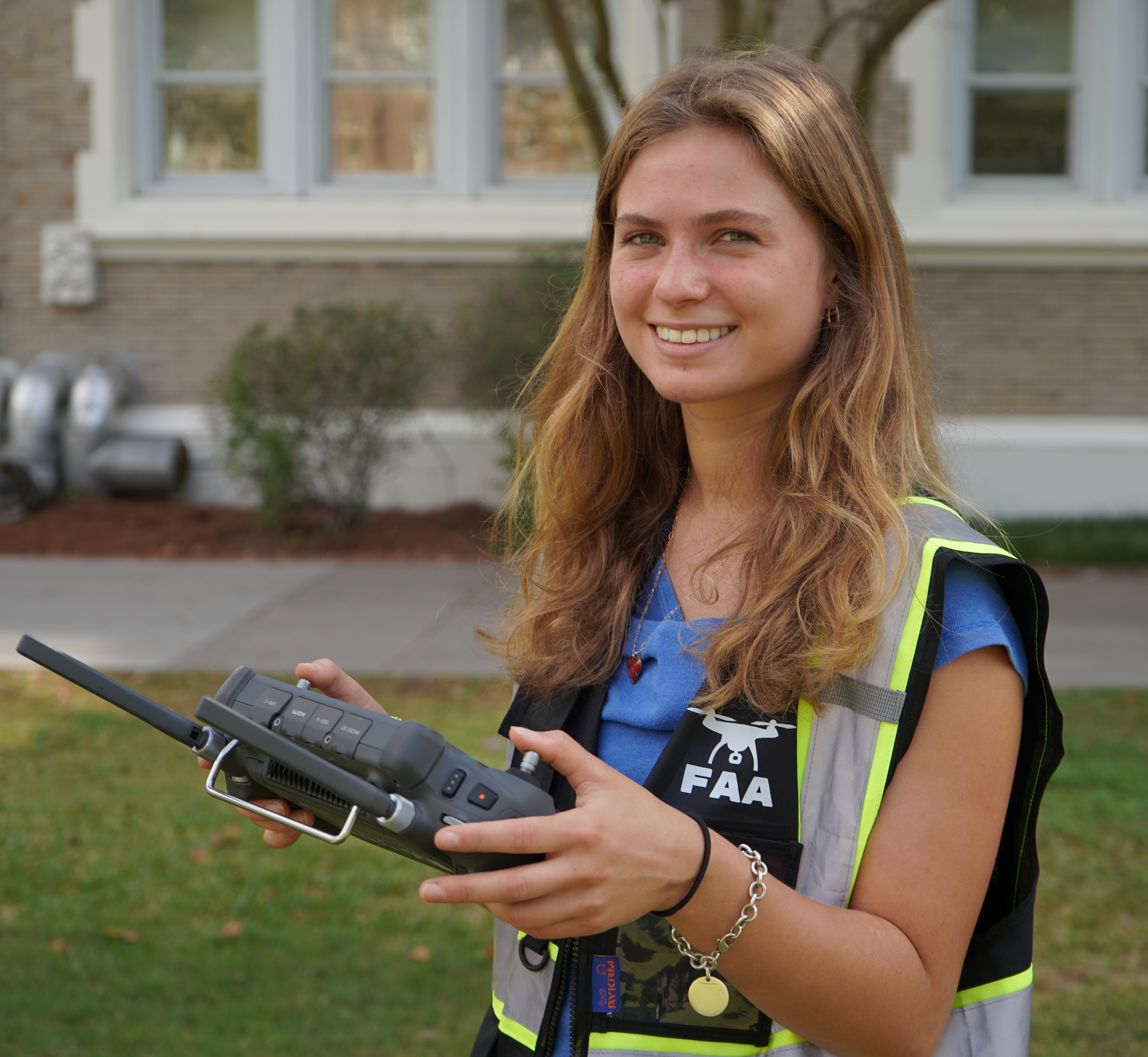 Girl in safety vest holding a remote controller