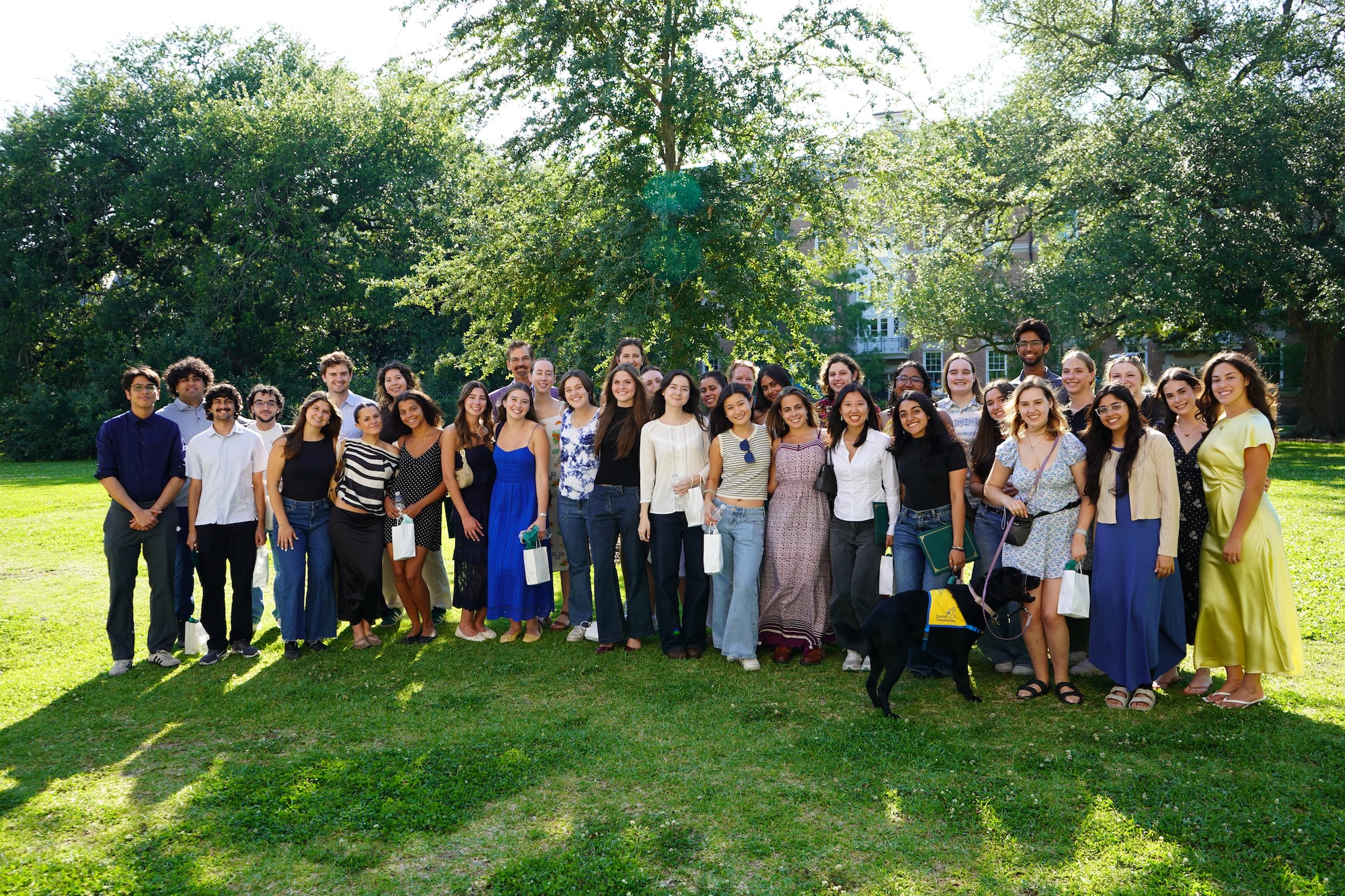 A large group of young adults poses for a photo outdoors.