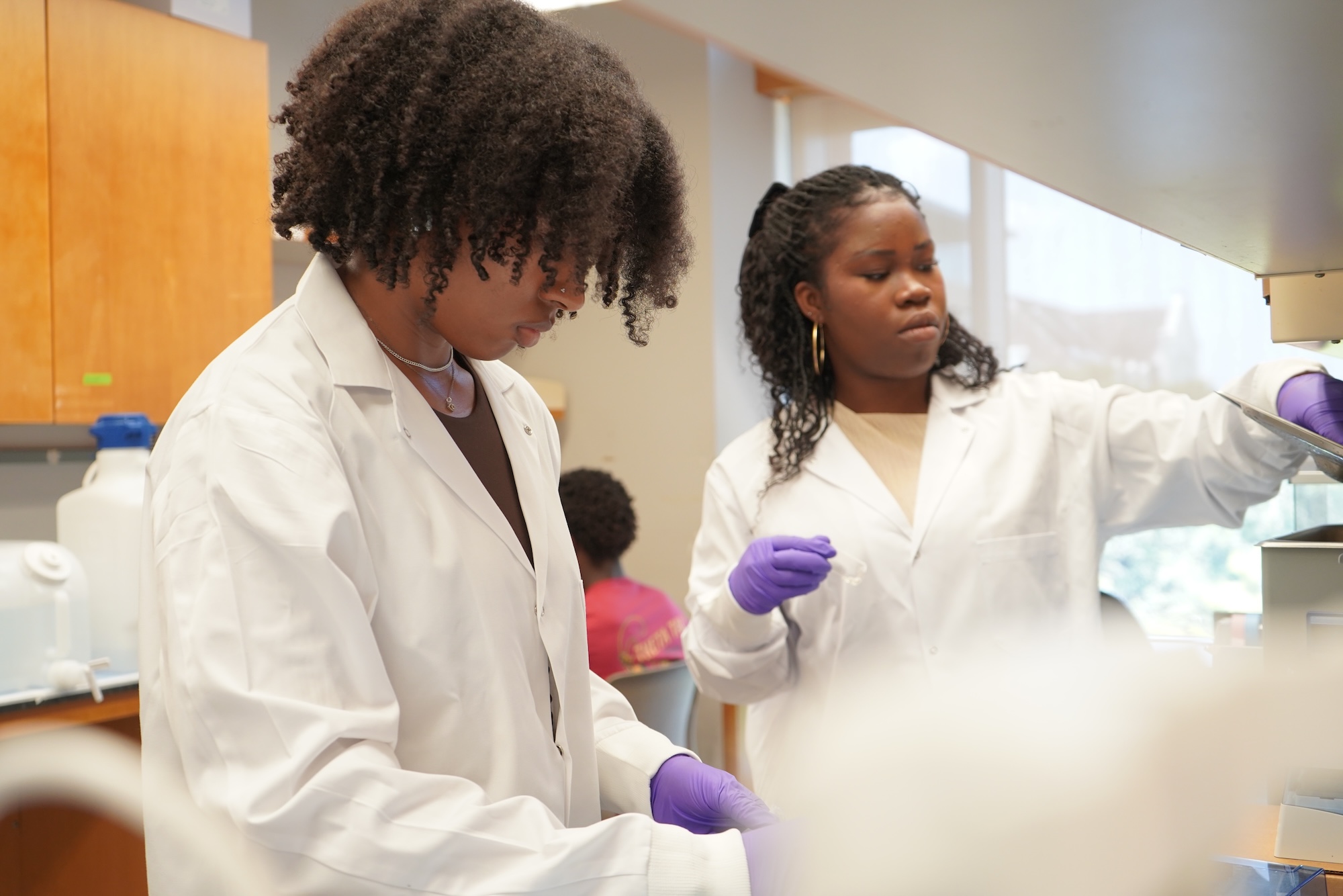 Two women in lab coats working in a laboratory.