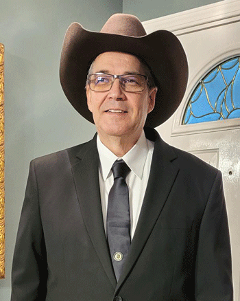 Man in cowboy hat, suit and tie, and glasses