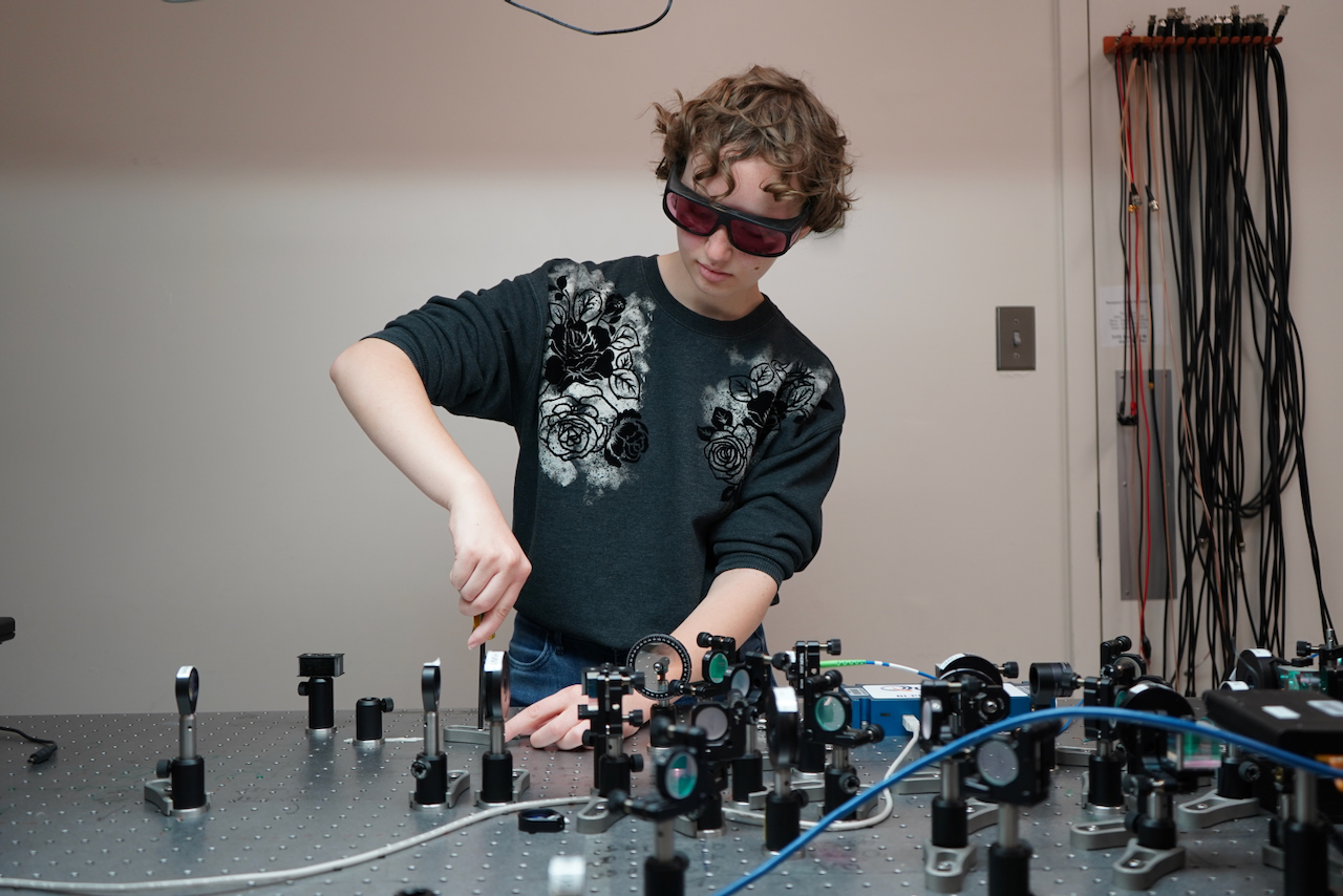 scientist wearing black glasses working on circuits