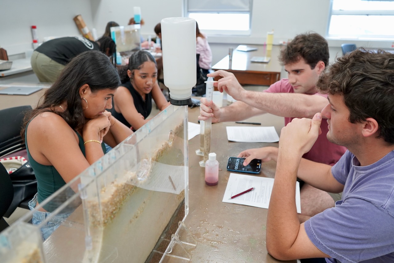 Students collaborate on a science experiment in a bright classroom.