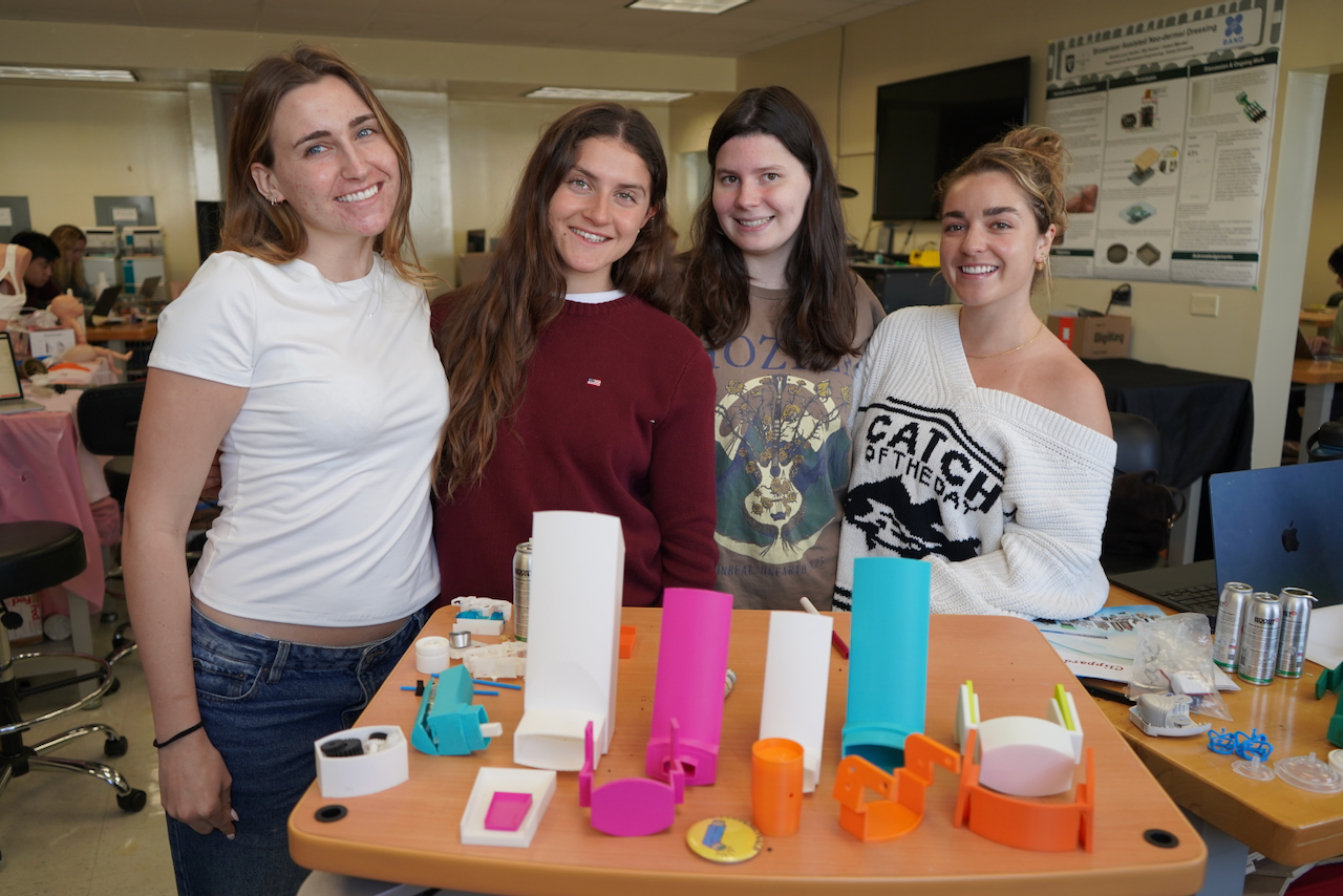four girls standing behind a table with colorful inhaler models