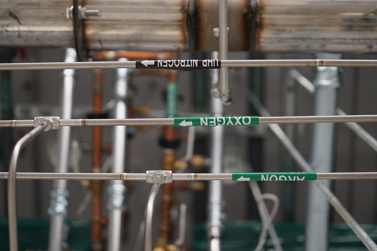 Green labels on pipes read "OXYGEN" and "NITROGEN."