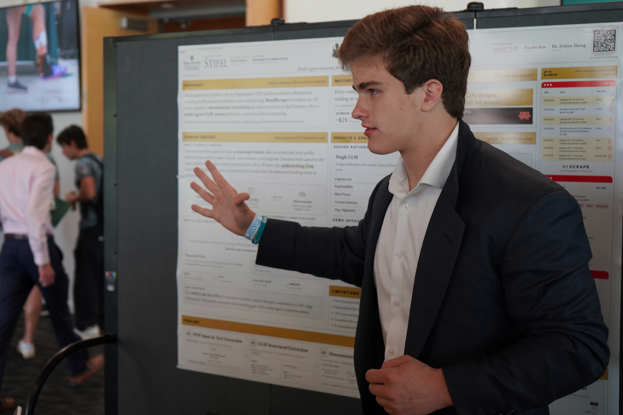 Young man in a suit presenting a research poster.