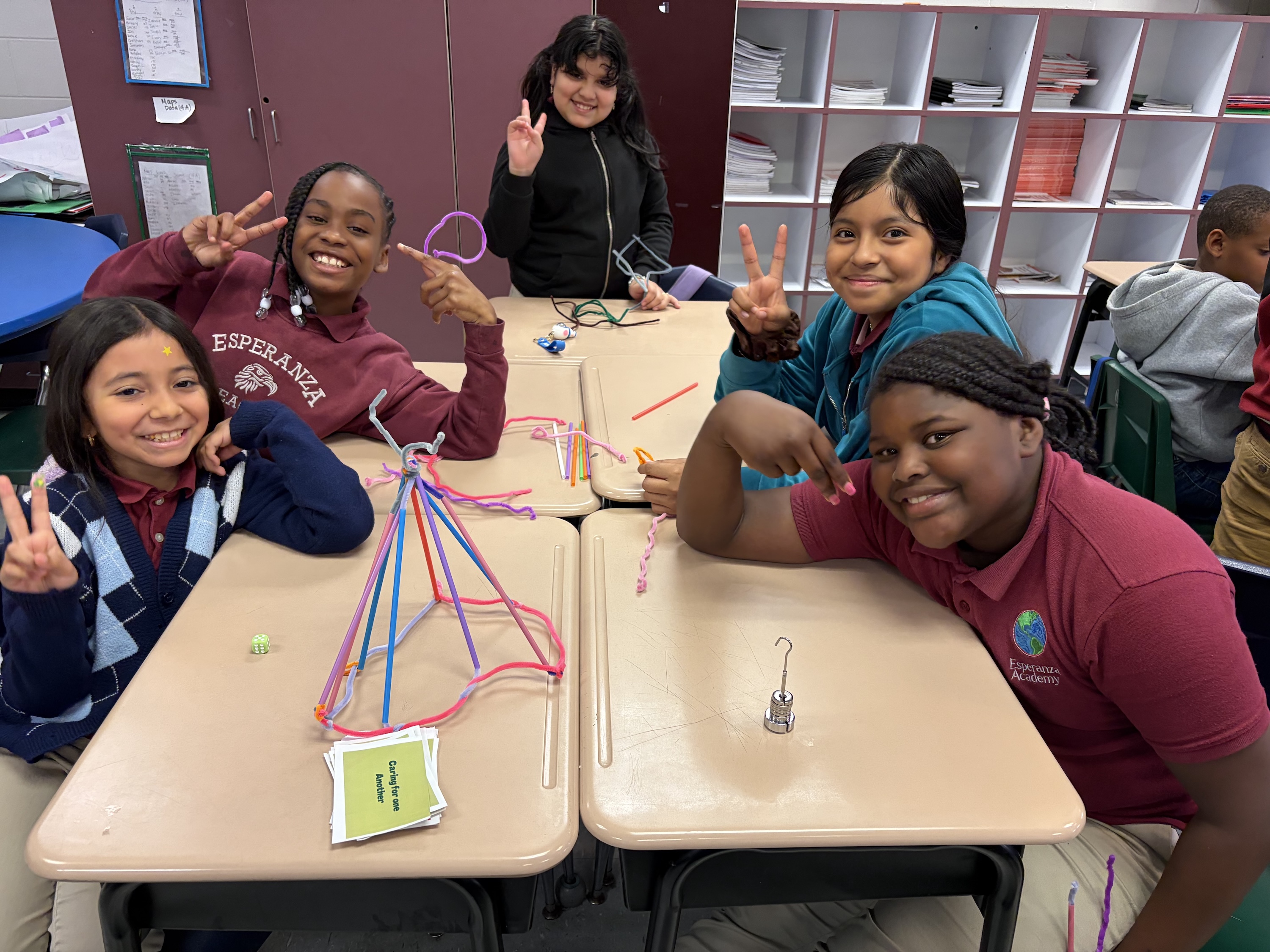 Group of smiling students doing a project at desks.