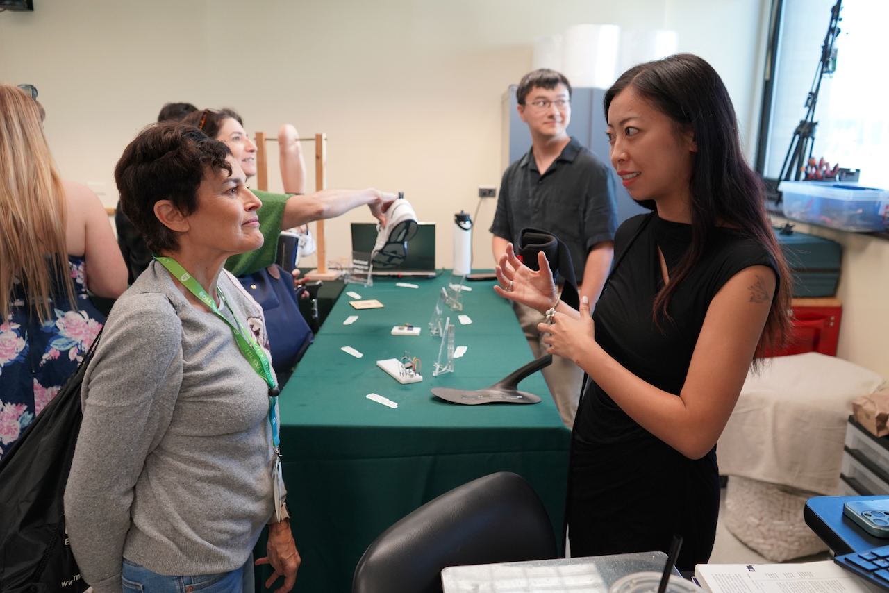 Photo of two women talking at a table in a bright room.
