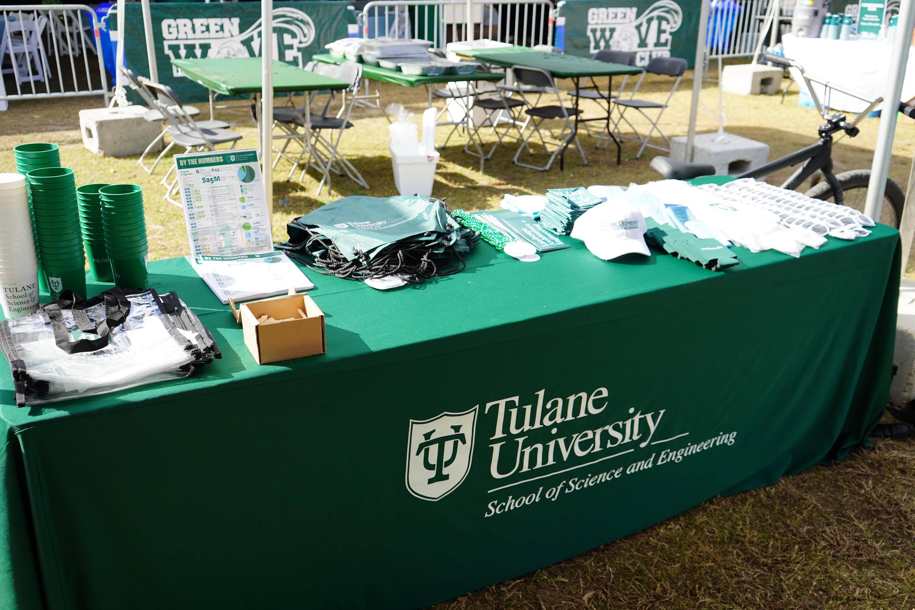 Photograph of a green Tulane University table at an outdoor event.