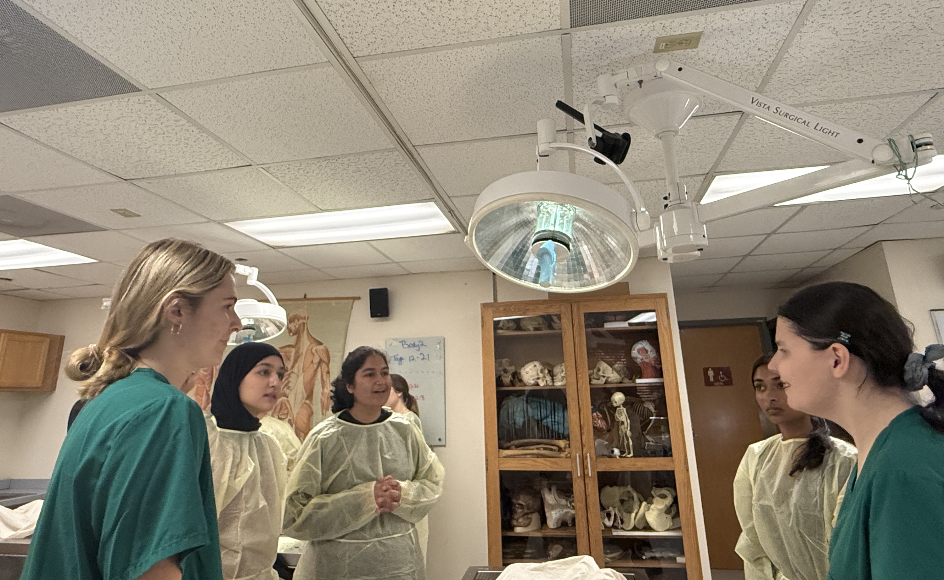 A group of students in medical scrubs in a brightly lit lab.