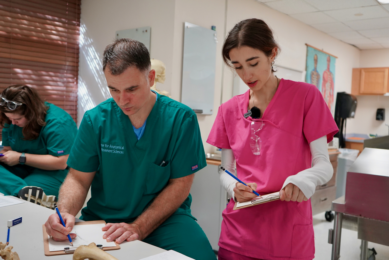 Photograph of medical students taking notes in a classroom.