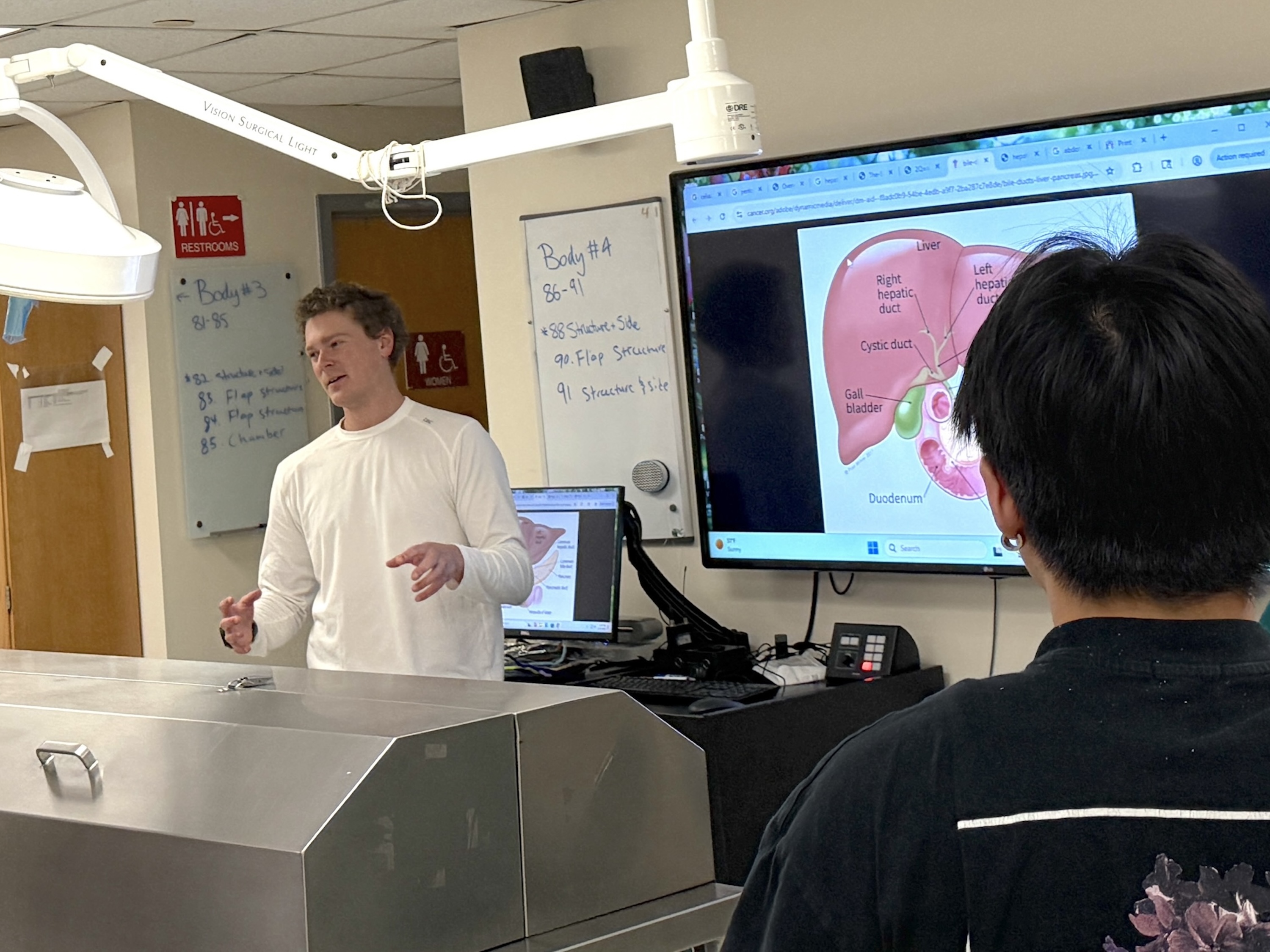 Photograph of an instructor teaching students in a medical lab.
