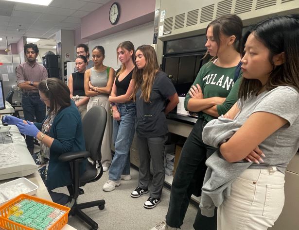 Photograph of a teacher and students in a science lab.
