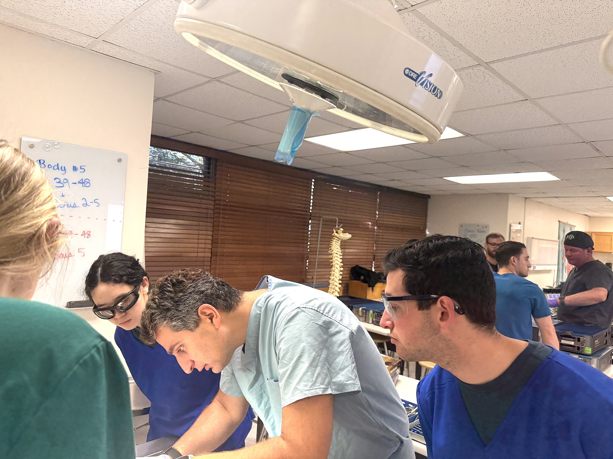 Photograph of students in scrubs learning in a clinical simulation lab.