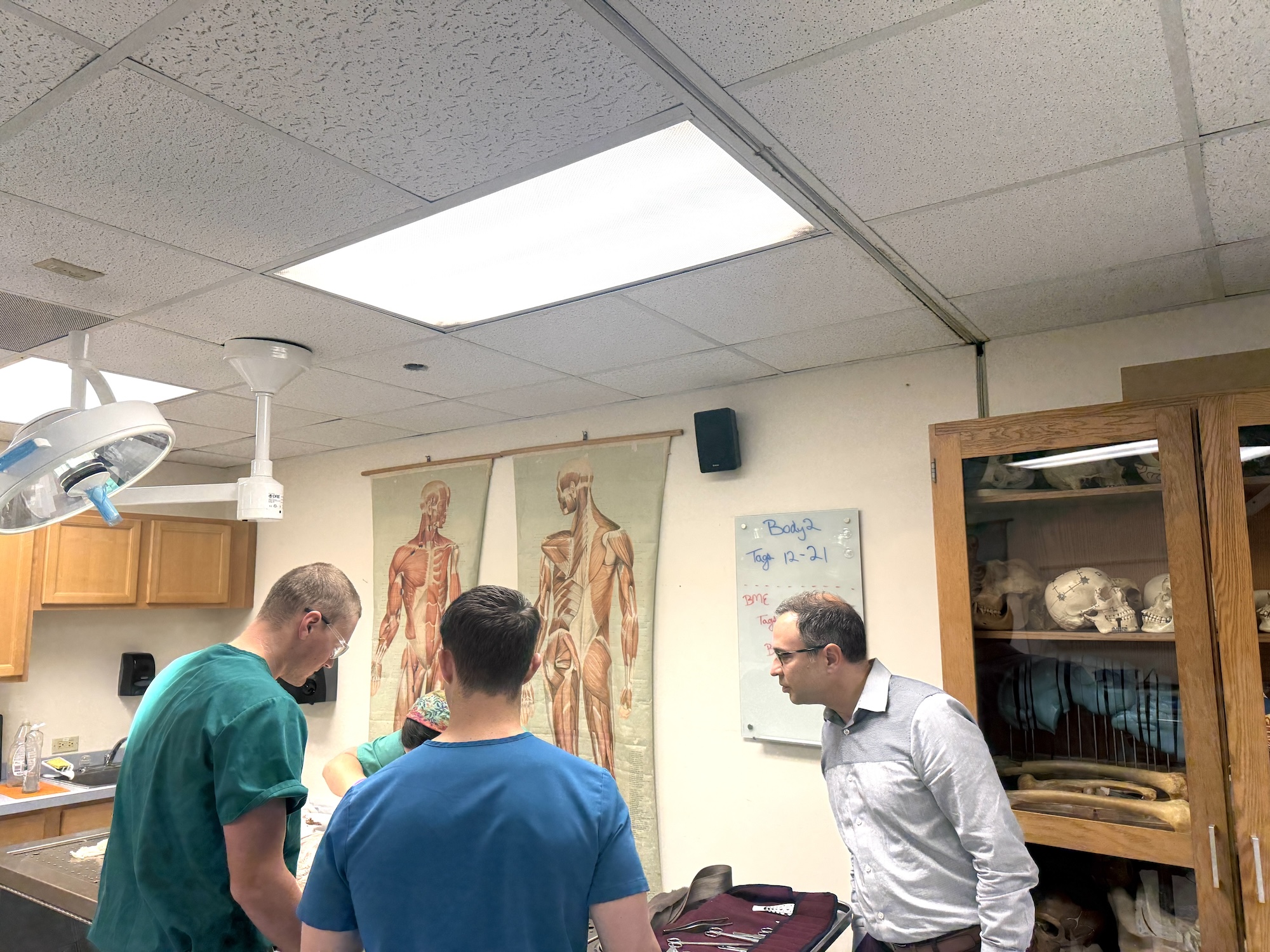 Photograph of students and an instructor gathered around a table in a biology classroom.
