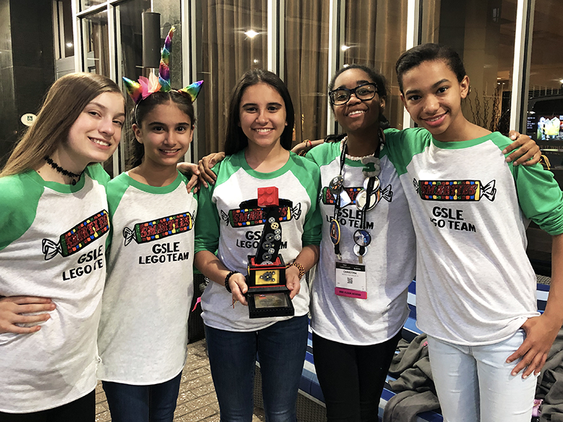 Girl Scouts pose with trophy from robotics competition. 