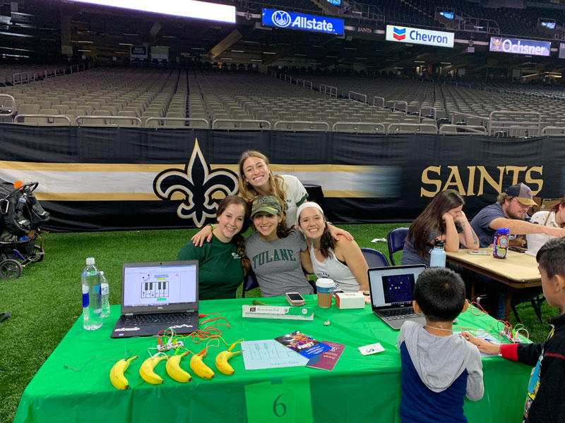 Student volunteers at Tulane table for Saints/Pelicans STEM Fest