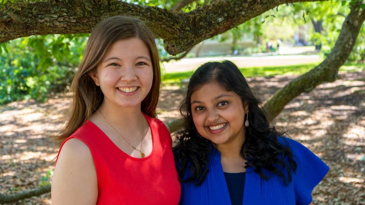 The two Goldwater female scholars smile and pose under a tree on Tulane's campus