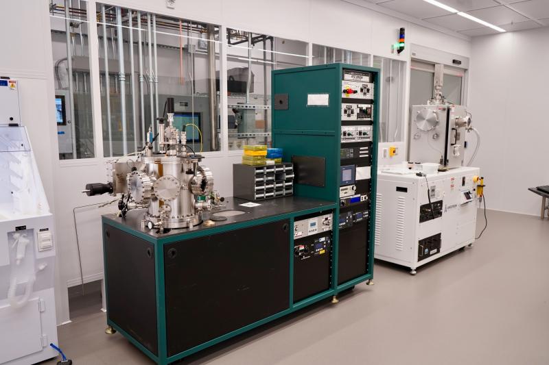 Photograph of a clean laboratory featuring scientific equipment and racks of electronics.