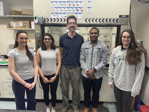 Students and instructor stand in front of fume hood