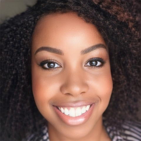 Close-up photograph of a young Black woman smiling widely.