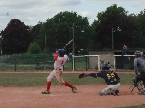 Baseball player swings bat at a game.