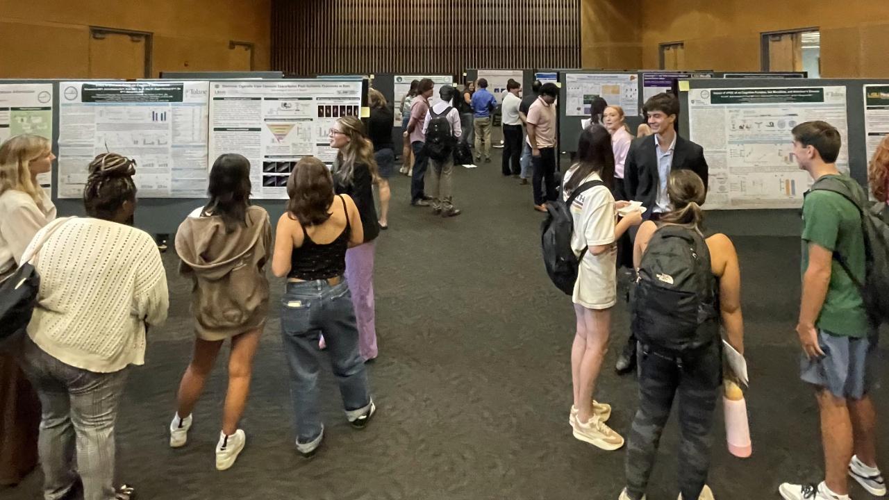 Students gather to review each other's poster presentations 