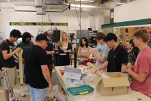 Group of students and an instructor working on a project in a workshop.